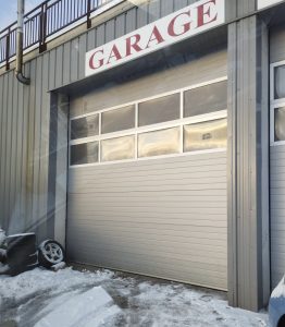 Porte sectionnelle industrielle installée sur un entrepôt, ouverture verticale et isolation renforcée
