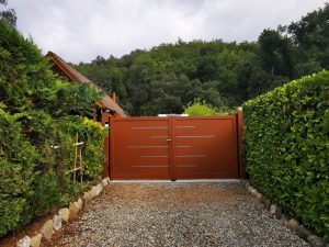 Portails battants en aluminium modernes installés en façade, design épuré et structure résistante